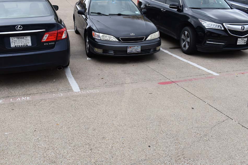 Image of a parking lot with a poorly marked/faded fire lane.