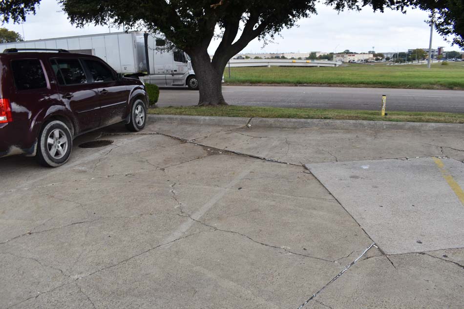 Close-up image of poorly marked/painted parking and fire lane in a parking lot.